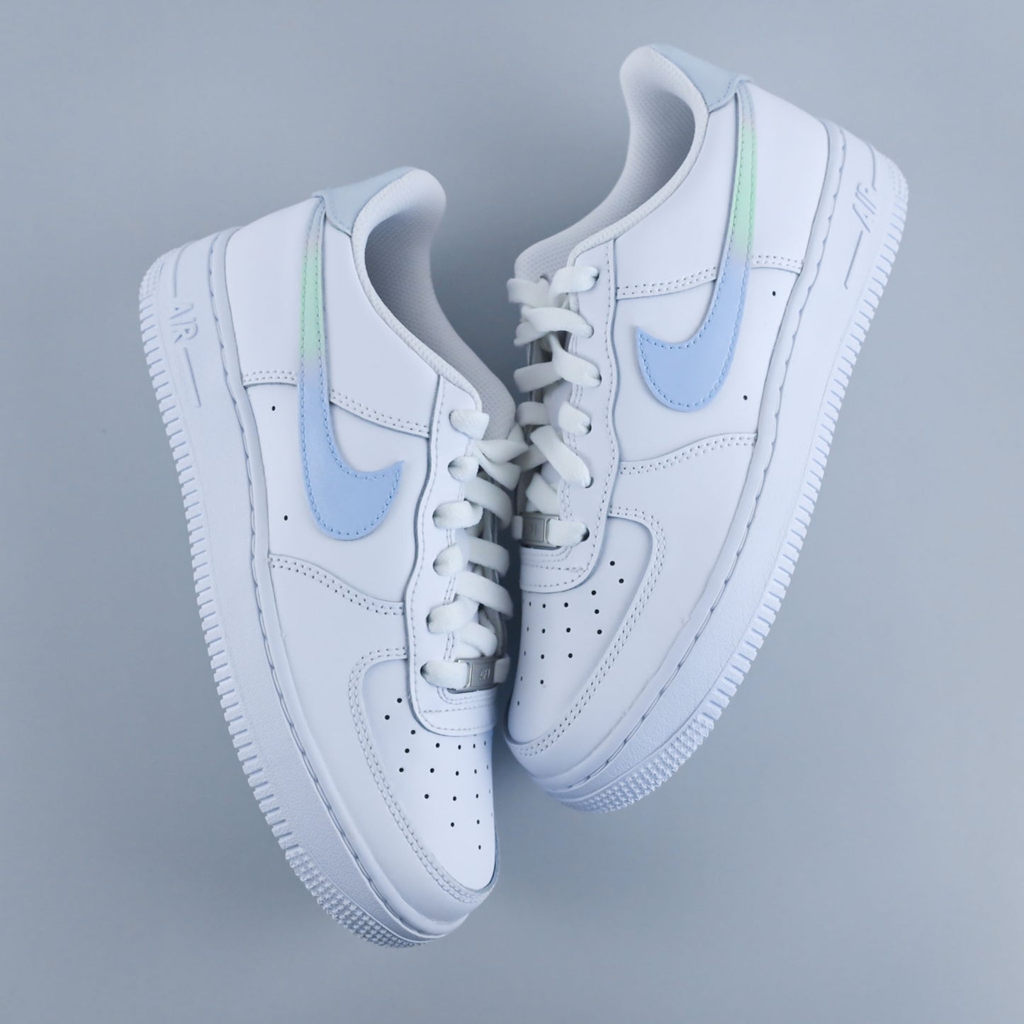 Baskets personnalisées Air Force 1 custom "Blue Breeze" blanches avec swoosh bleu ciel et dégradé vert pastel, création sur-mesure peinte à la main par Kings Custom.