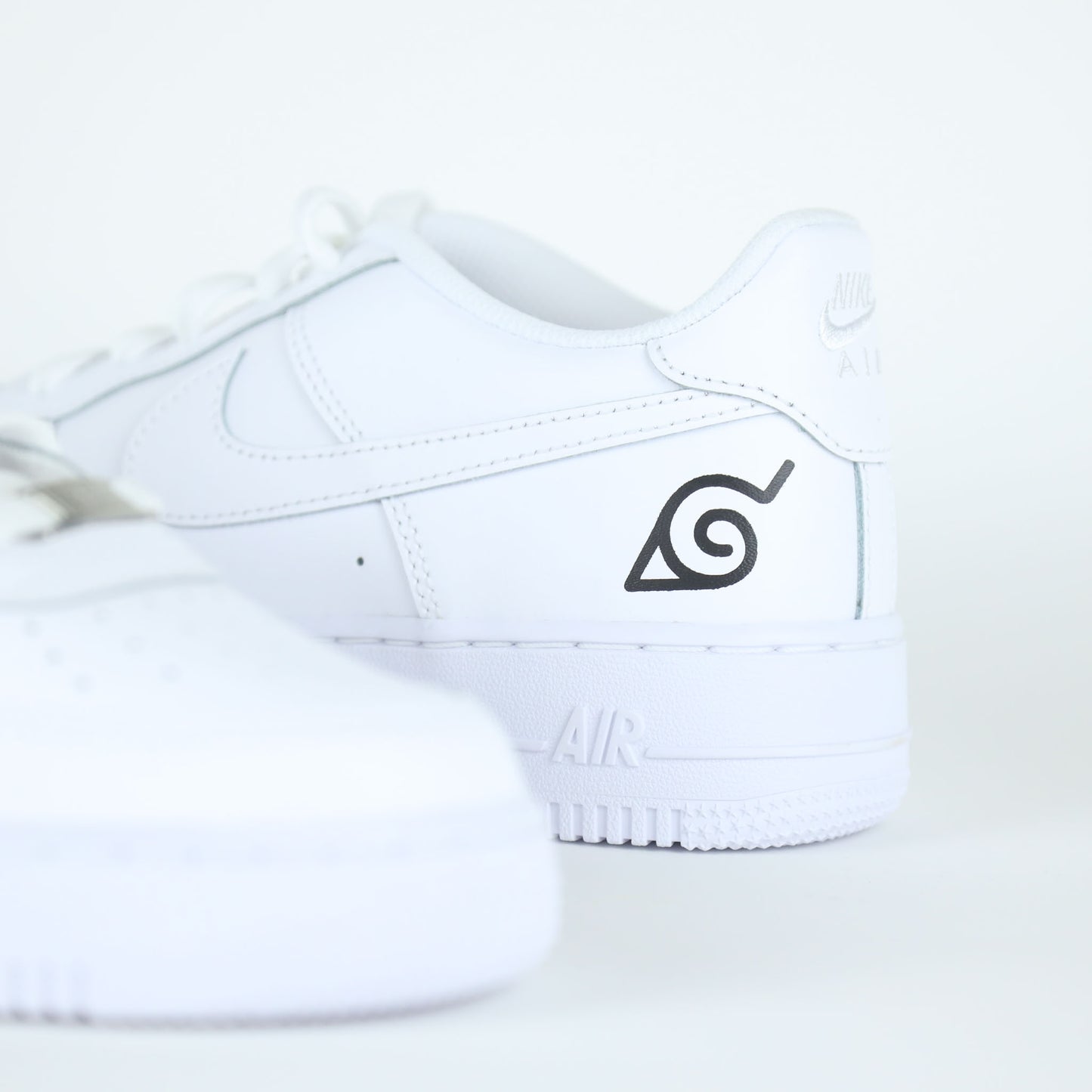 Nike Air Force 1 custom naruto manga Sasuke avec logo de Konoha et visage stylisé de Sasuke Uchiha
