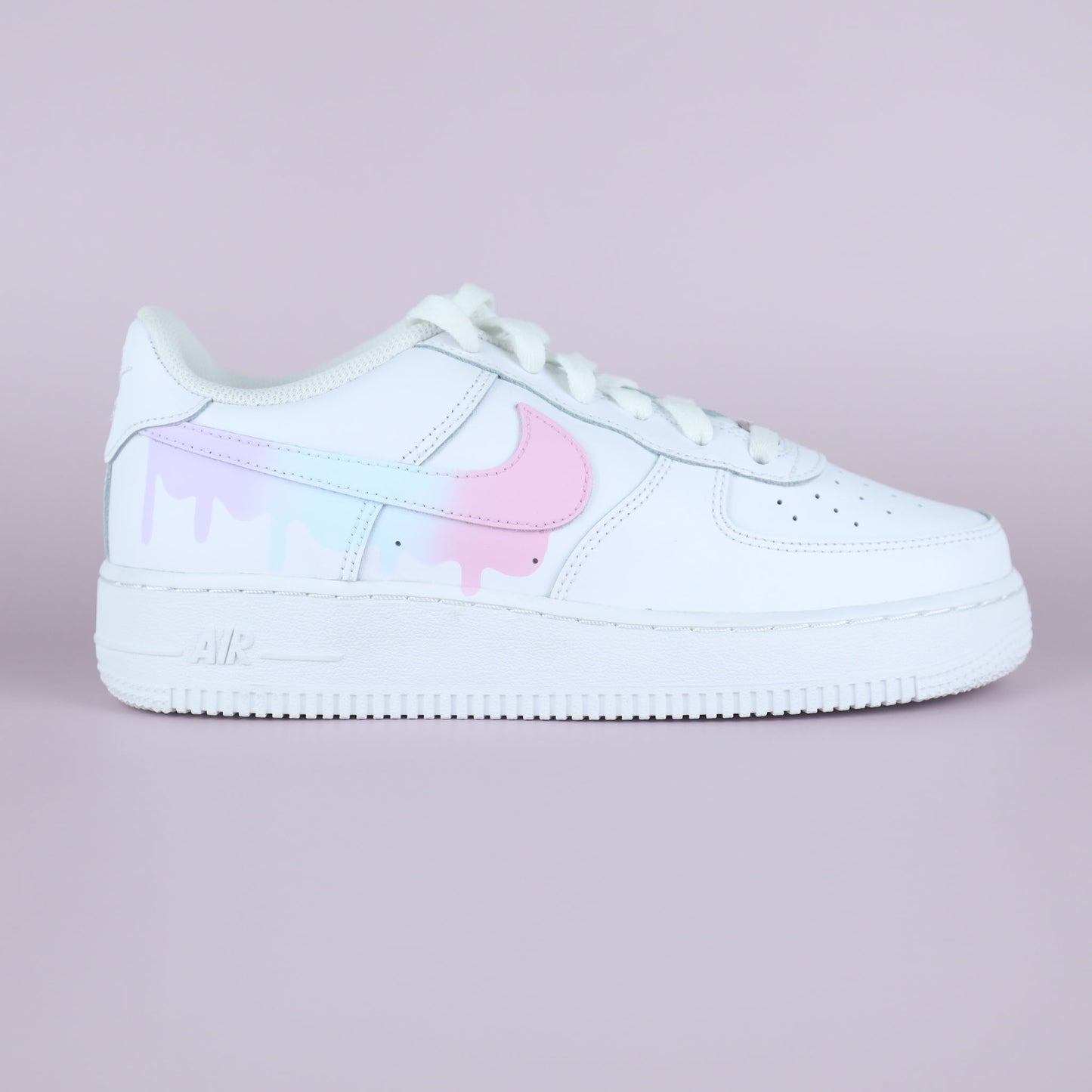 Nike Air Force 1 custom pastel drip avec swoosh rose et effet peinture coulant, vue latérale sur fond rose clair