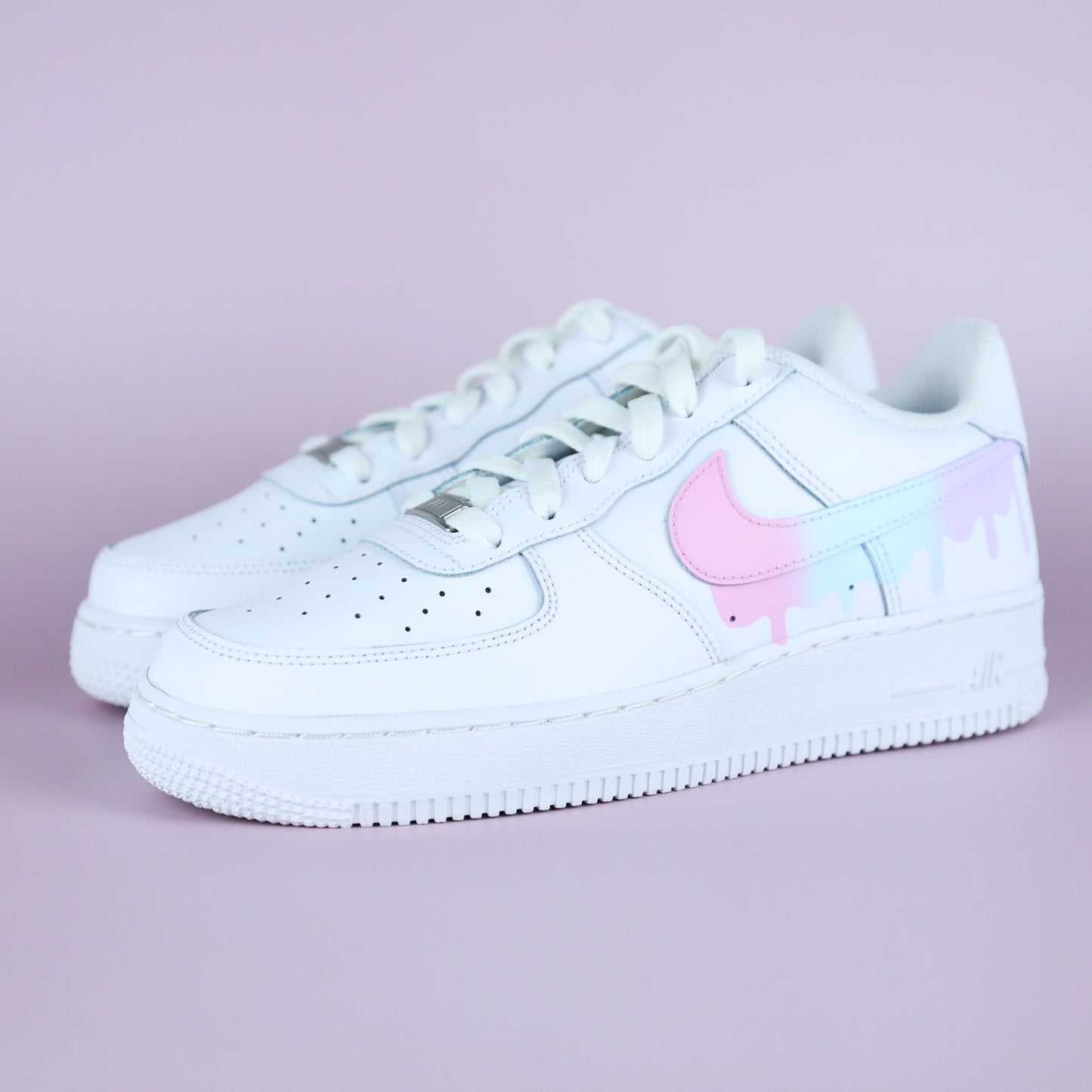 Nike Air Force 1 custom pastel drip avec swoosh rose et effet peinture coulant, vue latérale sur fond rose clair