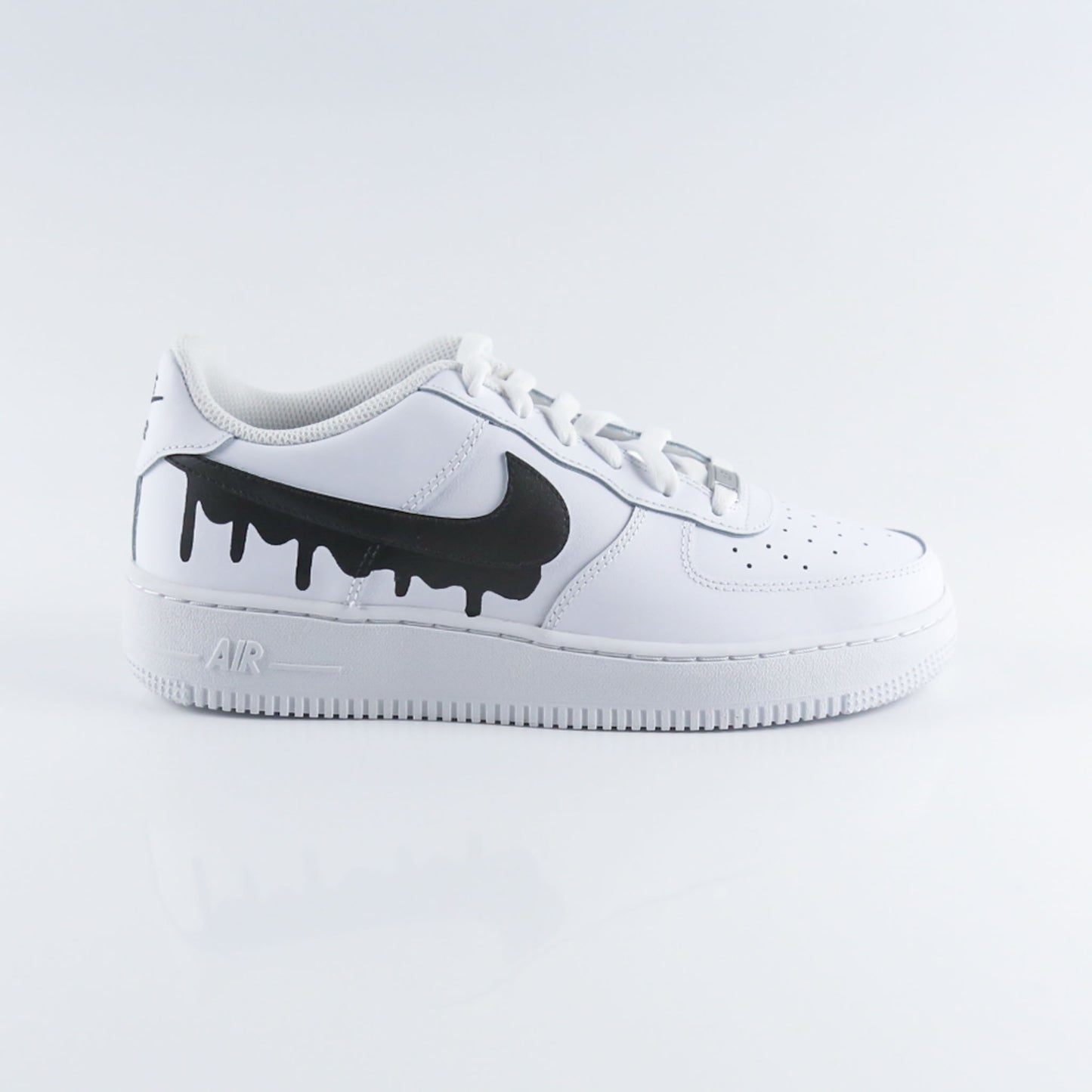 Nike Air Force 1 custom blanche en cuir premium avec Swoosh noir effet drip dégoulinant, sneakers streetwear unisex au design unique et original, chaussures personnalisées peintes à la main pour un style urbain tendance