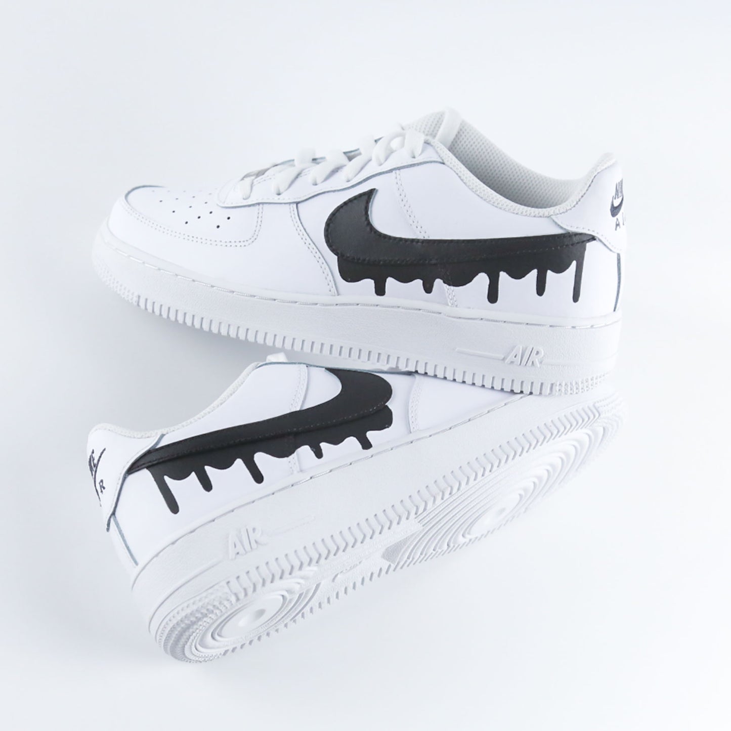 Nike Air Force 1 custom blanche en cuir premium avec Swoosh noir effet drip dégoulinant, sneakers streetwear unisex au design unique et original, chaussures personnalisées peintes à la main pour un style urbain tendance