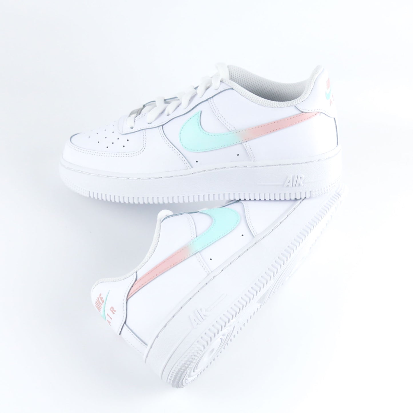 Nike Air Force 1 Custom blanche avec swoosh dégradé turquoise et rose pastel, design féminin et tendance. Sneakers personnalisées idéales pour femme, adolescente ou enfant, parfaites comme cadeau original et confortable pour toutes les occasions.