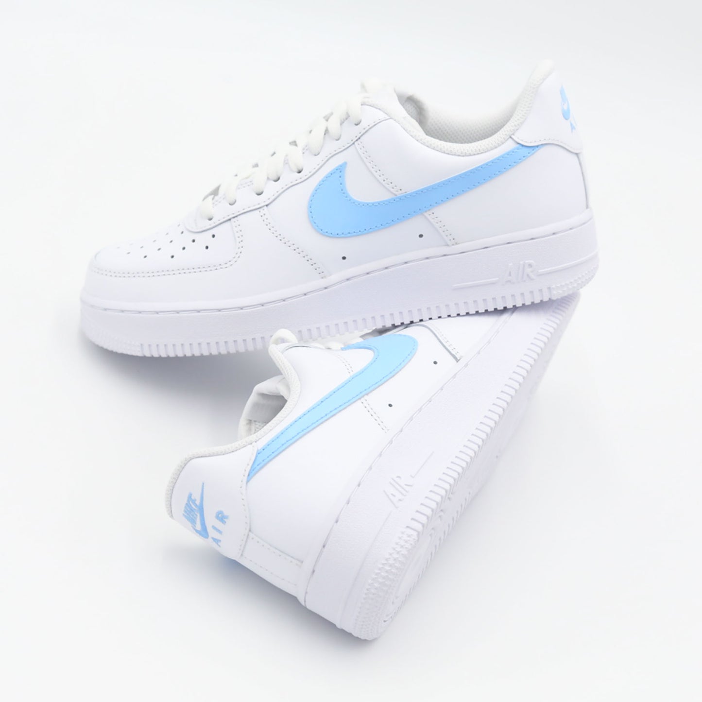 Nike Air Force 1 Custom blanche avec swoosh bleu ciel, design moderne et épuré pour un style unique. Sneakers customisées offrant confort, durabilité et polyvalence, idéales pour les tenues streetwear et casual.