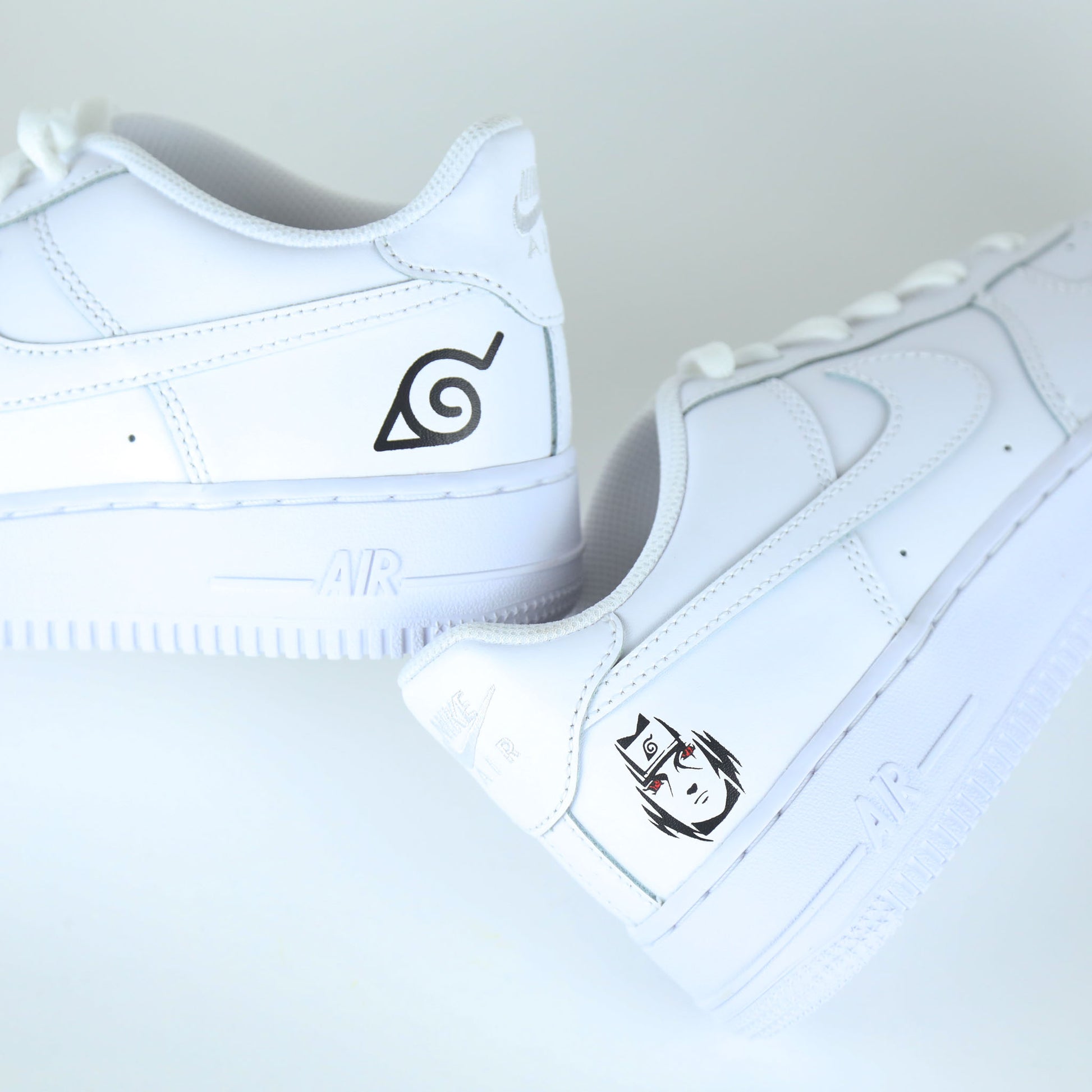 Nike Air Force 1 custom naruto manga Sasuke avec logo de Konoha et visage stylisé de Sasuke Uchiha