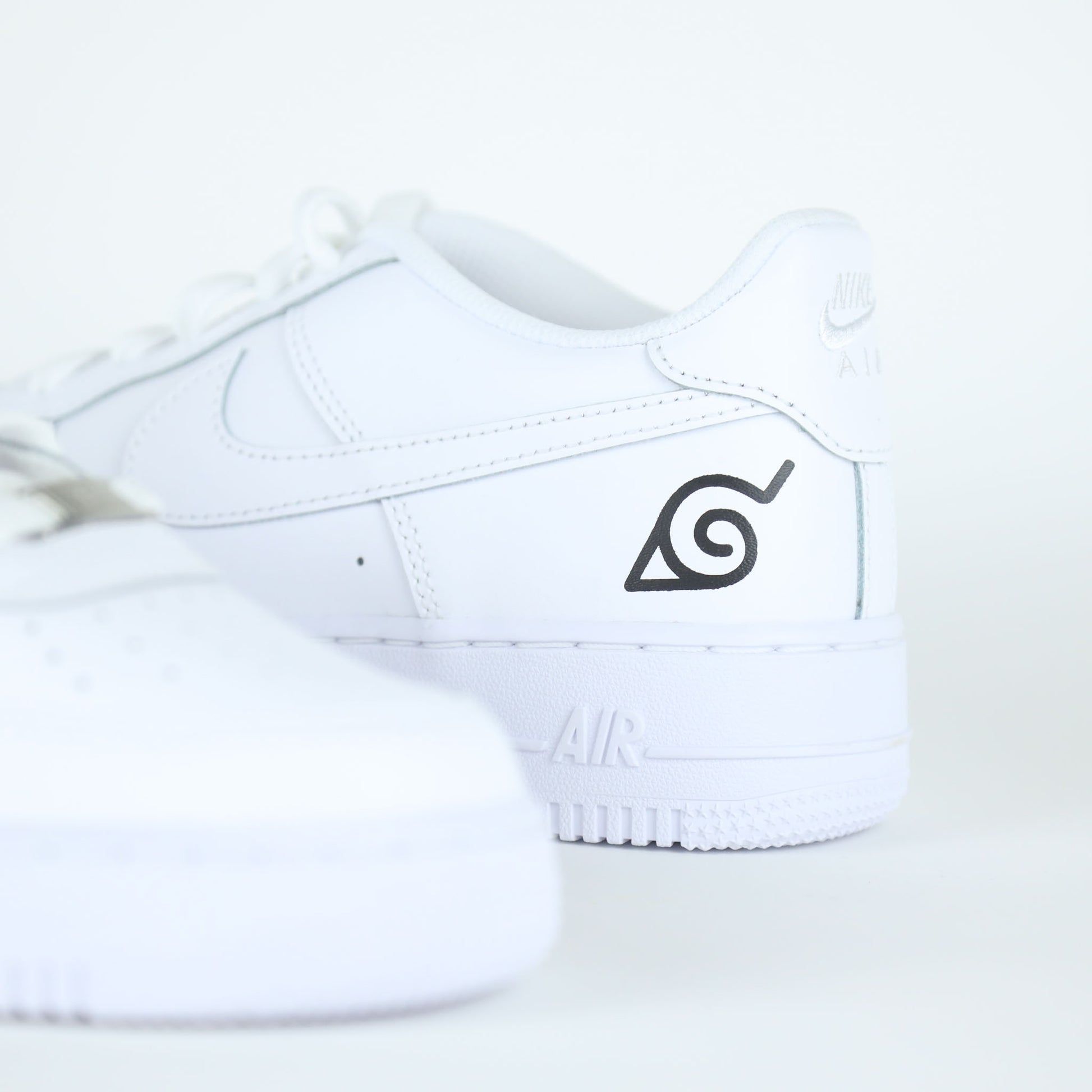 Nike Air Force 1 custom naruto manga Sasuke avec logo de Konoha et visage stylisé de Sasuke Uchiha
