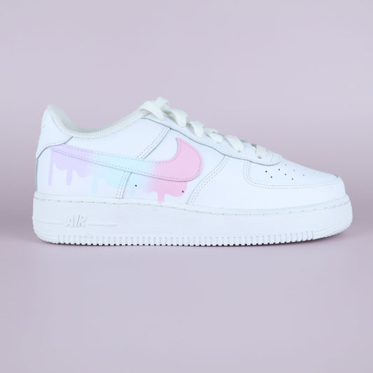 Nike Air Force 1 custom pastel drip avec swoosh rose et effet peinture coulant, vue latérale sur fond rose clair
