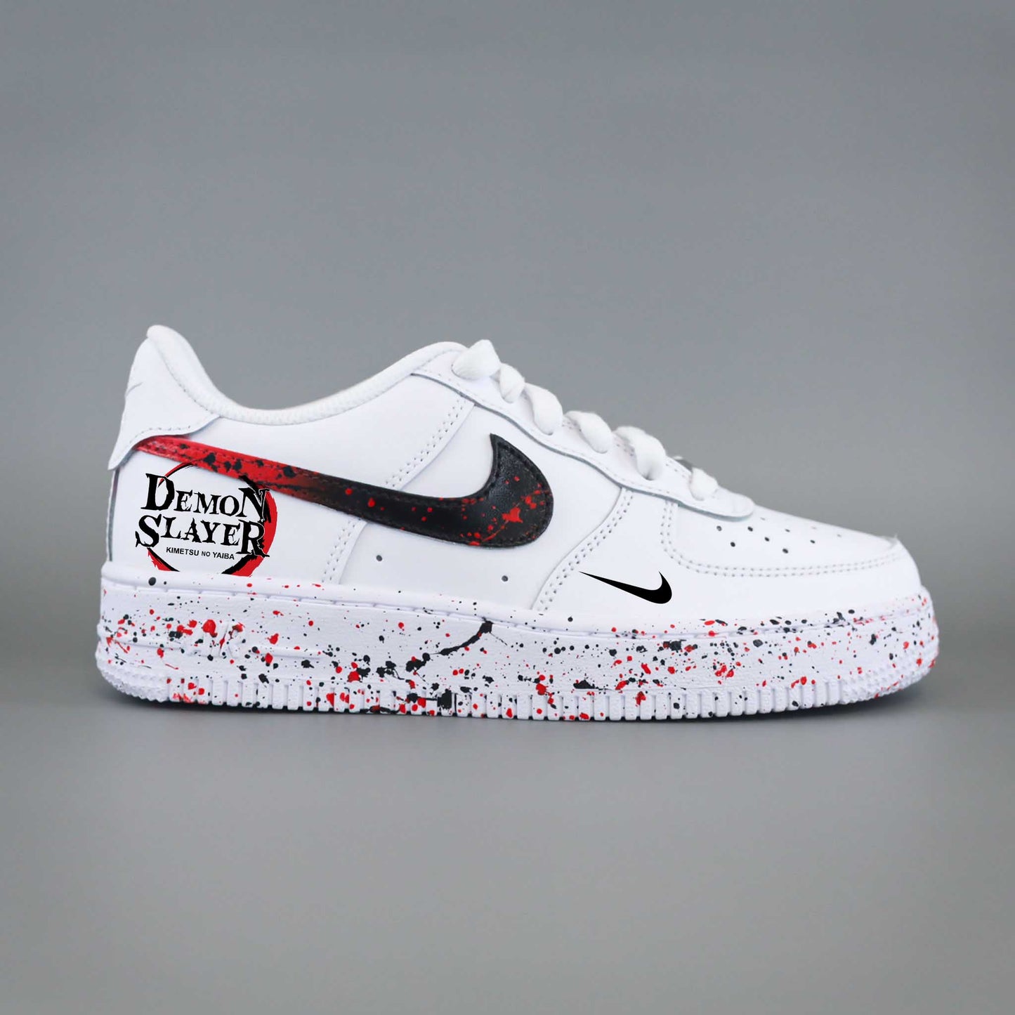 Nike Air Force 1 custom Demon Slayer Kimetsu no Yaiba avec swoosh noir éclaboussé de rouge et logo anime sur talon