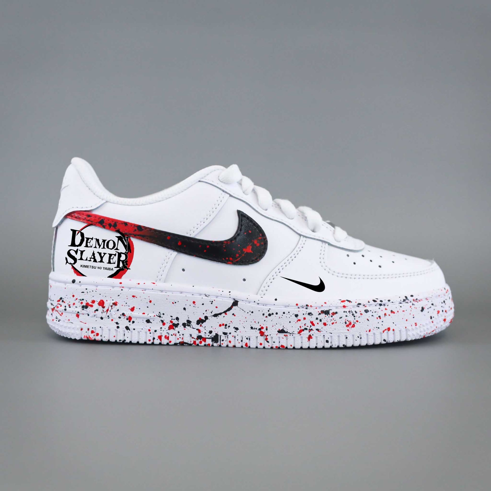 Nike Air Force 1 custom Demon Slayer Kimetsu no Yaiba avec swoosh noir éclaboussé de rouge et logo anime sur talon