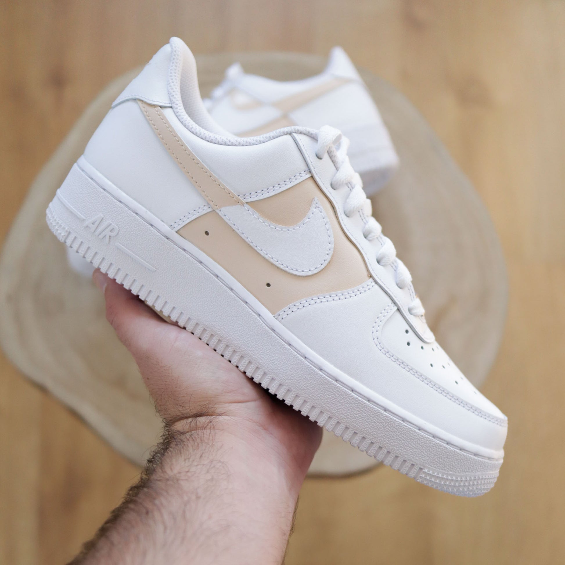 Découvre cette Nike Air Force 1 custom crème, peinte à la main sur base blanche. Une sneakers unique, sobre et tendance. Parfaite pour les fans de streetwear et de personnalisation.