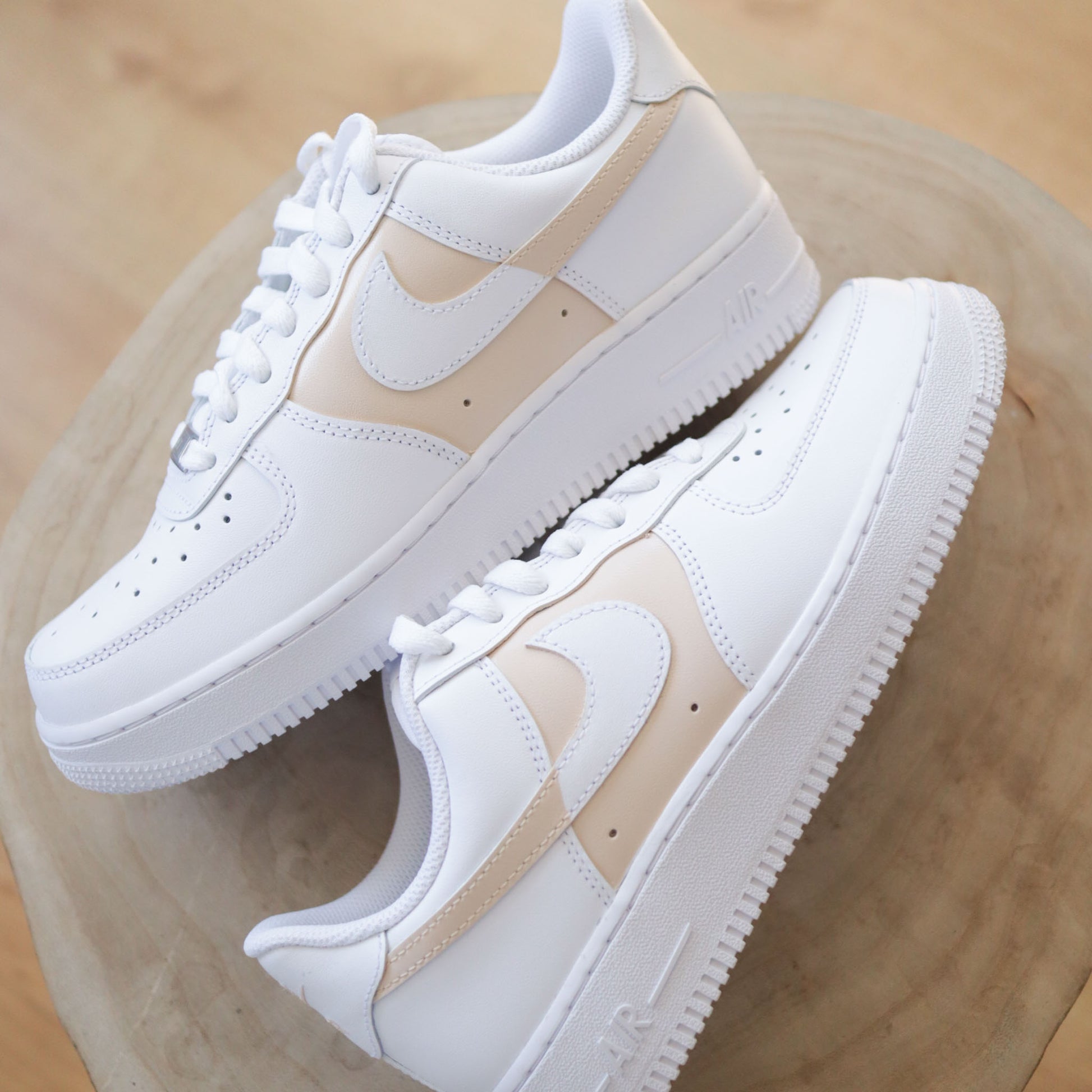 Découvre cette Nike Air Force 1 custom crème, peinte à la main sur base blanche. Une sneakers unique, sobre et tendance. Parfaite pour les fans de streetwear et de personnalisation.
