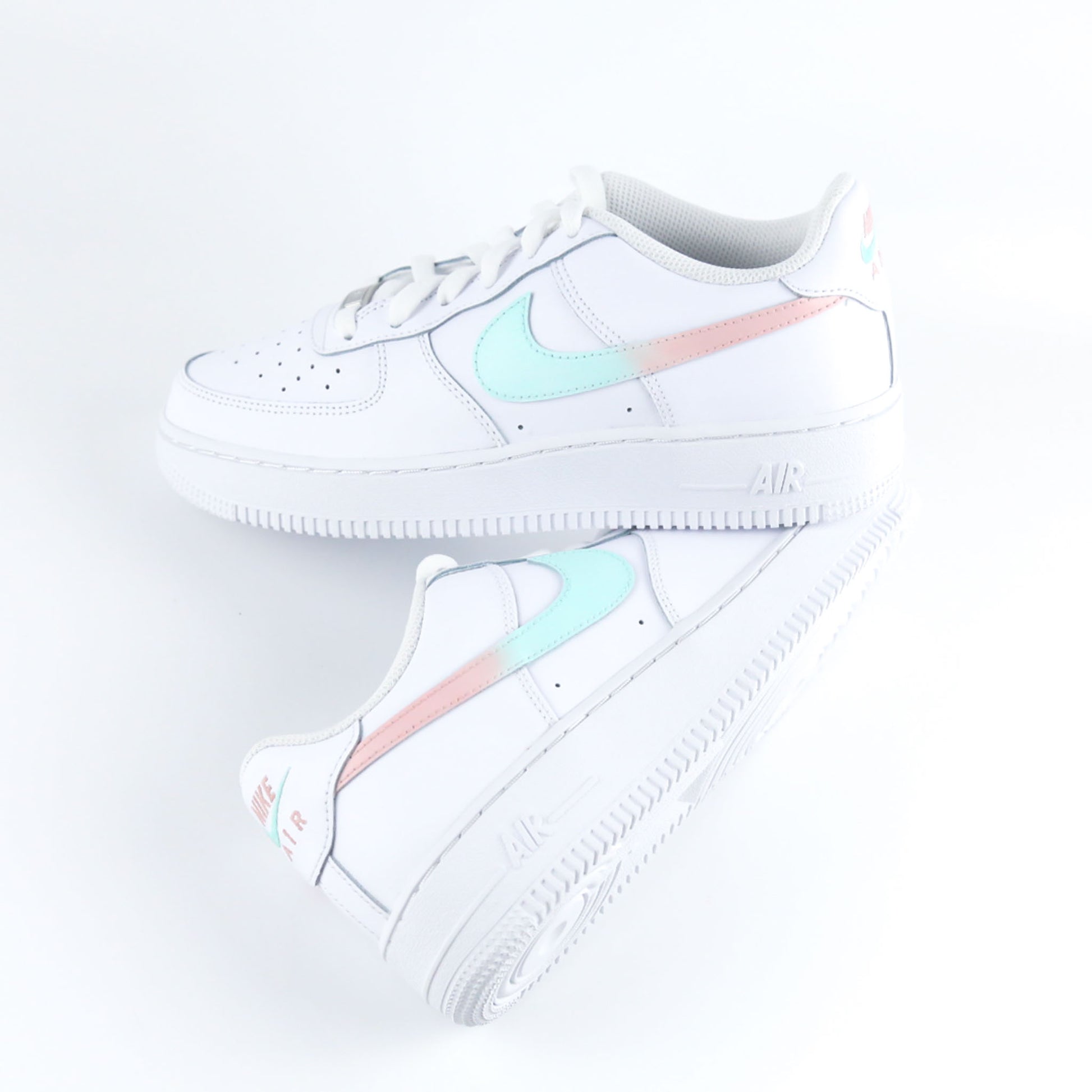 Nike Air Force 1 Custom blanche avec swoosh dégradé turquoise et rose pastel, design féminin et tendance. Sneakers personnalisées idéales pour femme, adolescente ou enfant, parfaites comme cadeau original et confortable pour toutes les occasions.