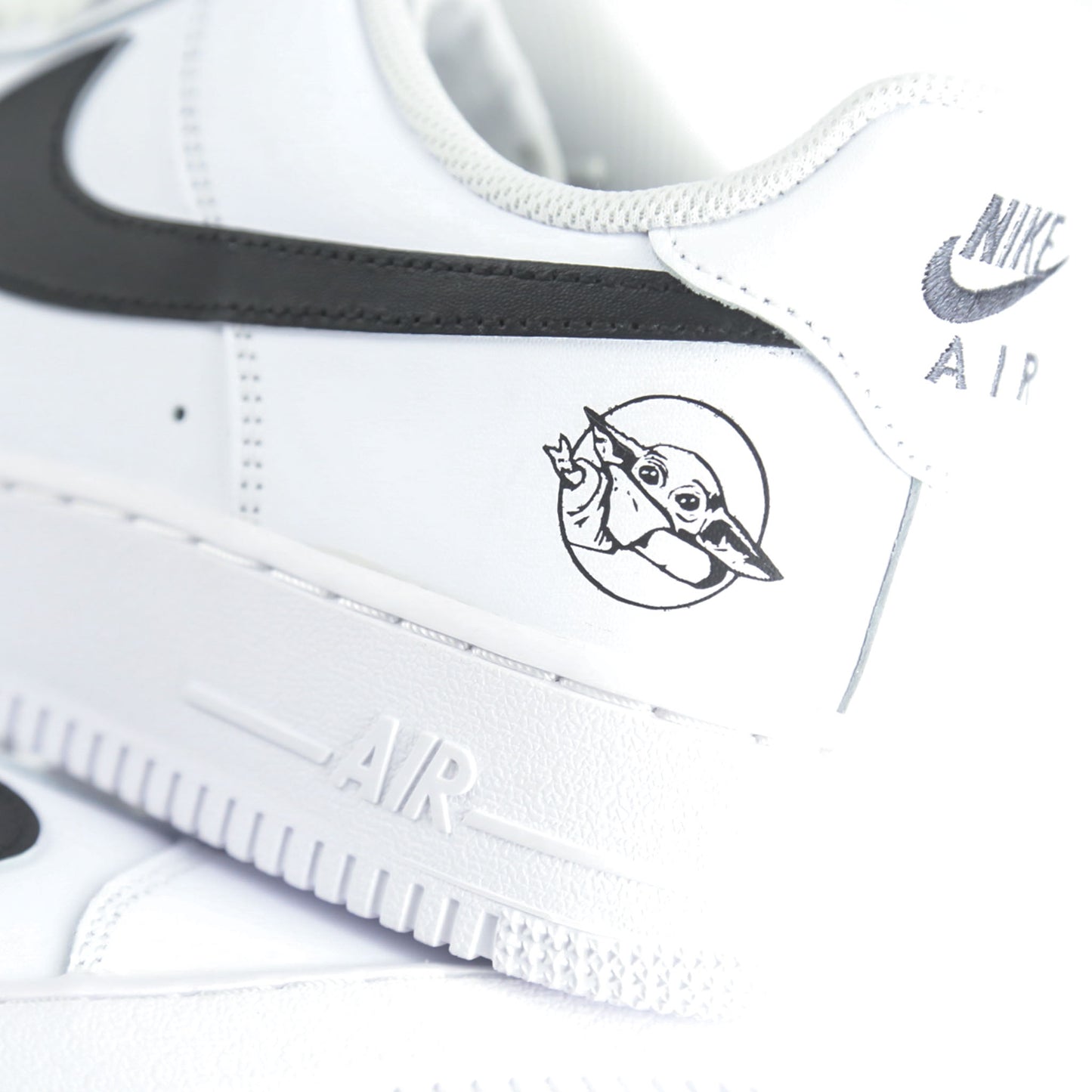  Nike Air Force 1 Custom blanche inspirée de Star Wars et de la série The Mandalorian, avec illustration Baby Yoda (Grogu) et détails rappelant l’armure du Mandalorien. Sneakers customisées streetwear geek pour fans de science-fiction et collectionneurs de l’univers Star Wars.