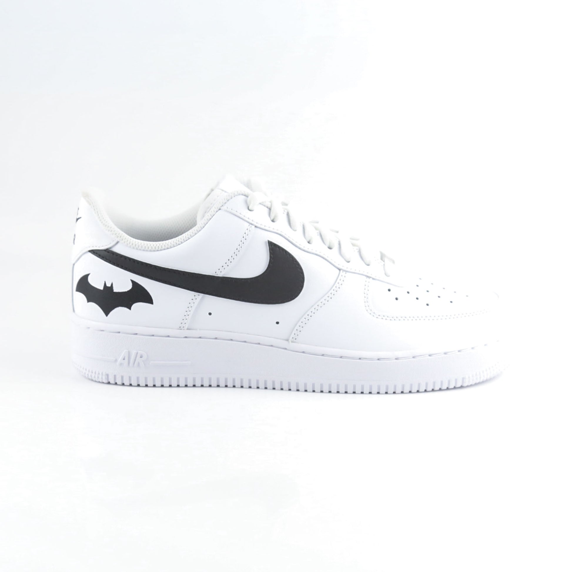 Nike Air Force 1 Custom blanche avec swoosh noir et logo Batman à l’arrière, inspirée de Gotham City, Batman, le Joker et l’univers DC Comics. Sneakers customisées streetwear haut de gamme pour fans de super-héros, comics et baskets personnalisées.