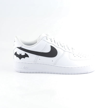 Nike Air Force 1 Custom blanche avec swoosh noir et logo Batman à l’arrière, inspirée de Gotham City, Batman, le Joker et l’univers DC Comics. Sneakers customisées streetwear haut de gamme pour fans de super-héros, comics et baskets personnalisées.