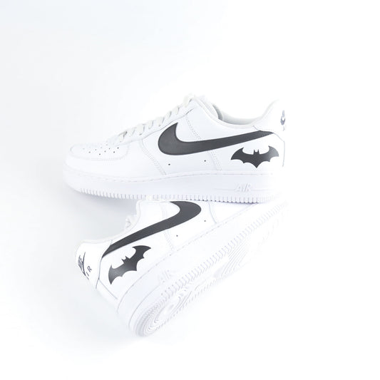Nike Air Force 1 Custom blanche avec swoosh noir et logo Batman à l’arrière, inspirée de Gotham City, Batman, le Joker et l’univers DC Comics. Sneakers customisées streetwear haut de gamme pour fans de super-héros, comics et baskets personnalisées.