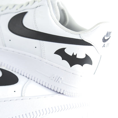 Nike Air Force 1 Custom blanche avec swoosh noir et logo Batman à l’arrière, inspirée de Gotham City, Batman, le Joker et l’univers DC Comics. Sneakers customisées streetwear haut de gamme pour fans de super-héros, comics et baskets personnalisées.