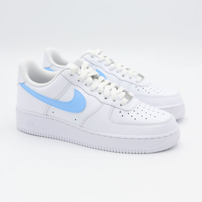 Nike Air Force 1 Custom blanche avec swoosh bleu ciel, design moderne et épuré pour un style unique. Sneakers customisées offrant confort, durabilité et polyvalence, idéales pour les tenues streetwear et casual.